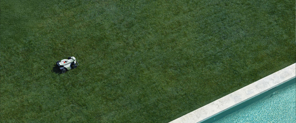 Navimow i Series robot lawn mower on grass near pool.