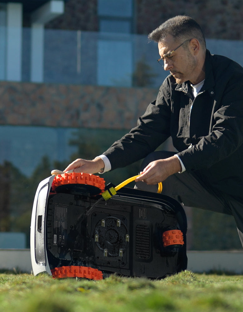 Navimow i Series robot lawn mower being washed by man.